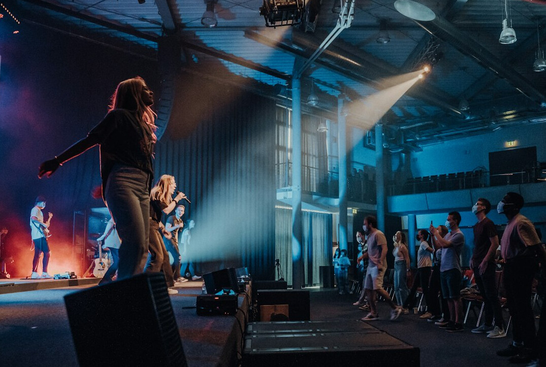Speaker rehearsing on stage with coach backstage